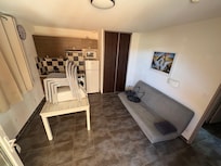 Pièce à vivre avec table qui double de longueur avec les rallonges, clic clac qui fait couchage deux personnes, télévision, machine à laver et frigo avec congélateur ainsi qu’un grand placard à balais (tout le matériel de cuisine nécessaire)