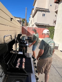 Guys grilling fresh fish from fish market at end of pier in Avila