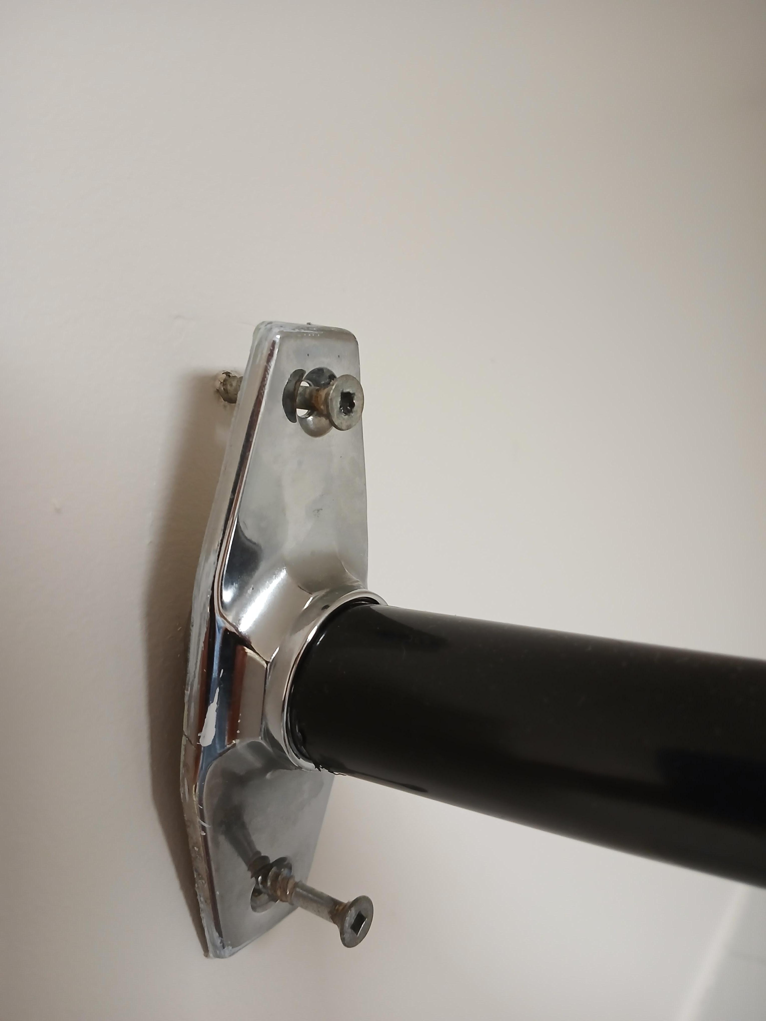 support de douche maintenu difficilement par de vis à peine pénétrées dans le mur