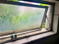 janela banheiro, trinco e dobradiça quebrada e amarrada com fio.