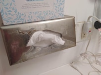 Kleenex box resting on a rusty kleenex dispenser?