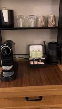 Coffee maker, coffee station, electric kettle, mugs and ice bucket in room.