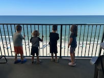 Kids on the balcony overlooking the ocean.
