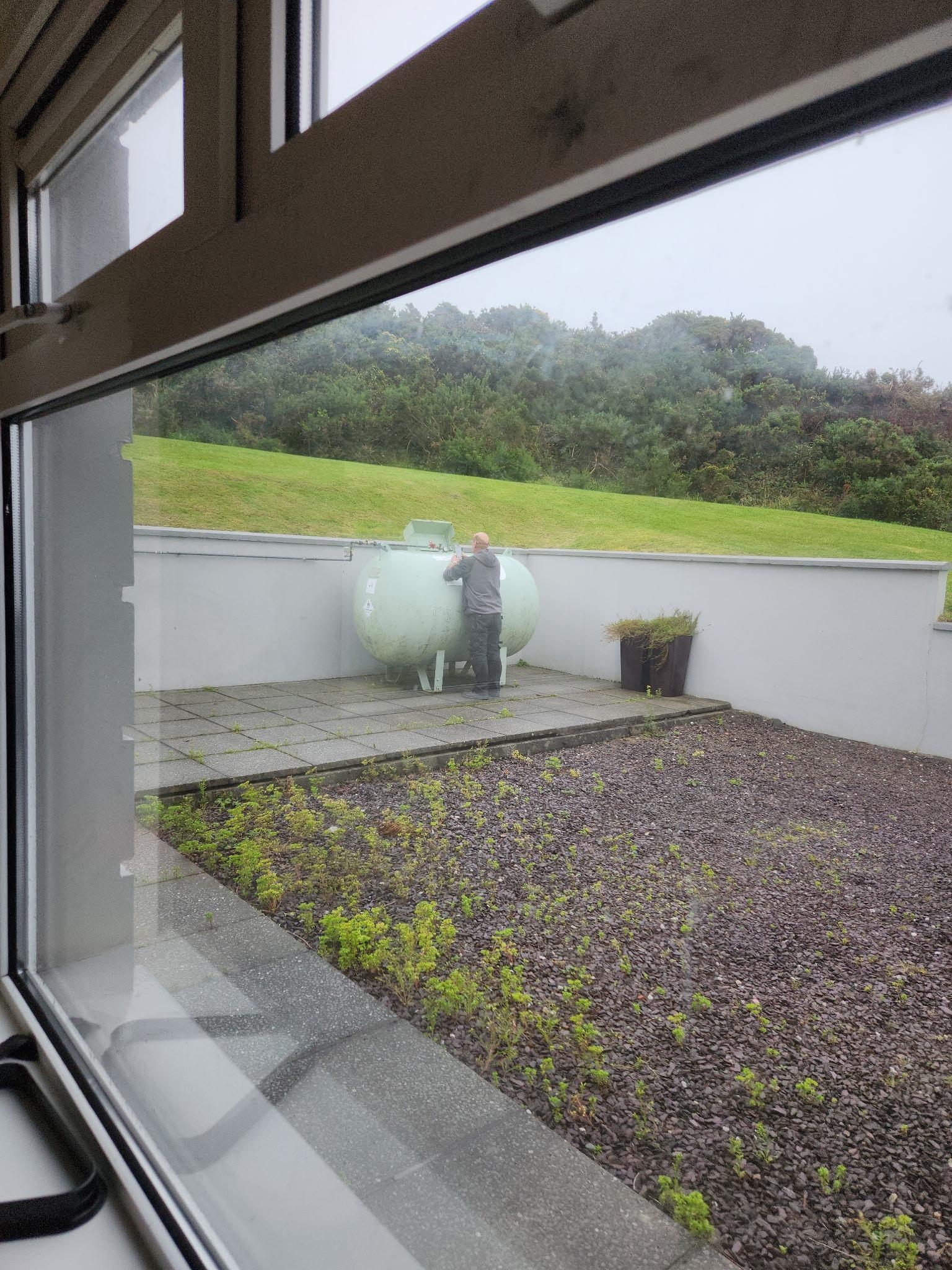 Man looking at fuel tank gauge.