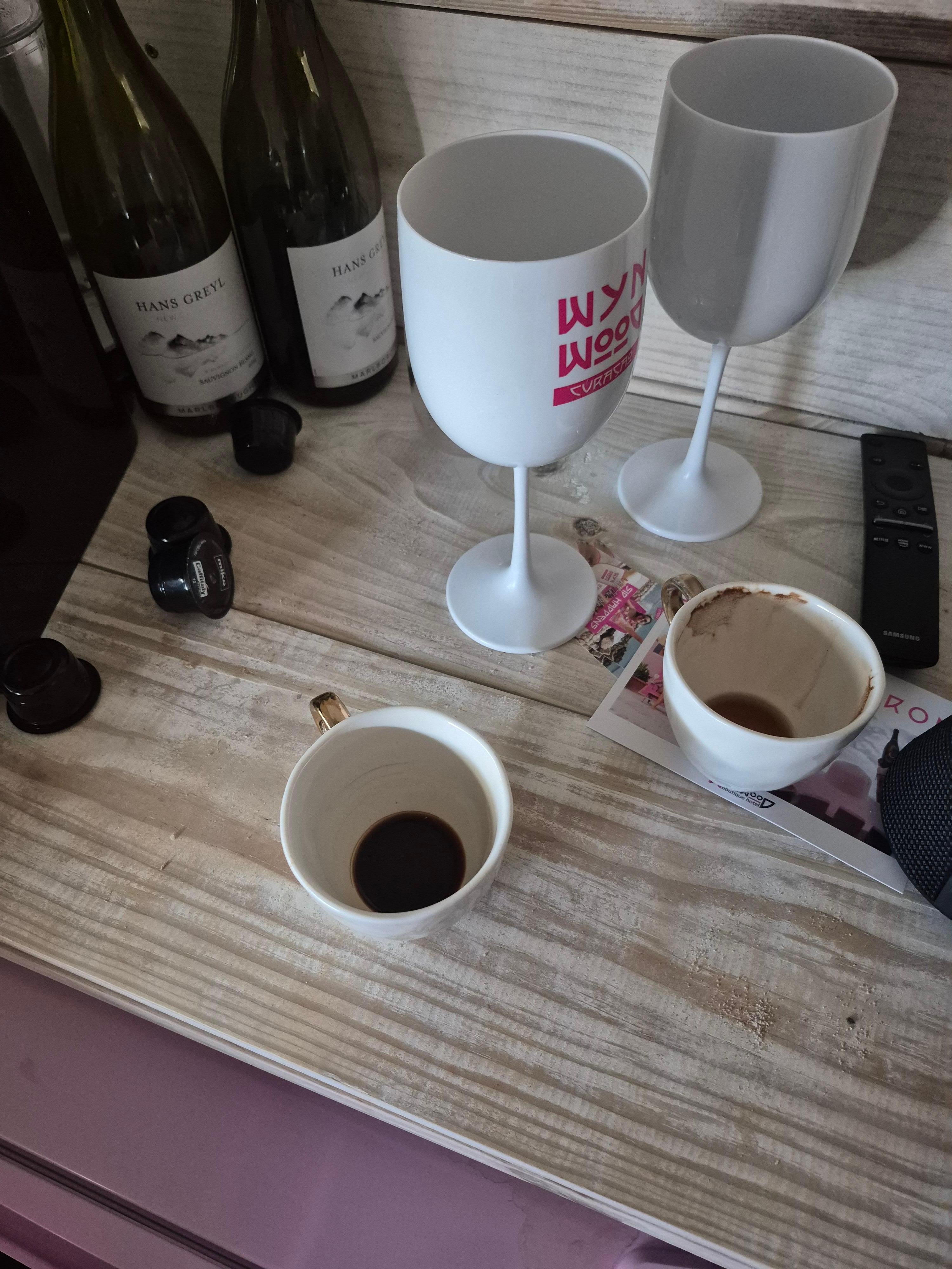 Dirty coffee cups and empty wine bottl3s