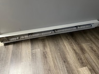 Baseboard heater panel, should have a cover. This unsafe if little children.