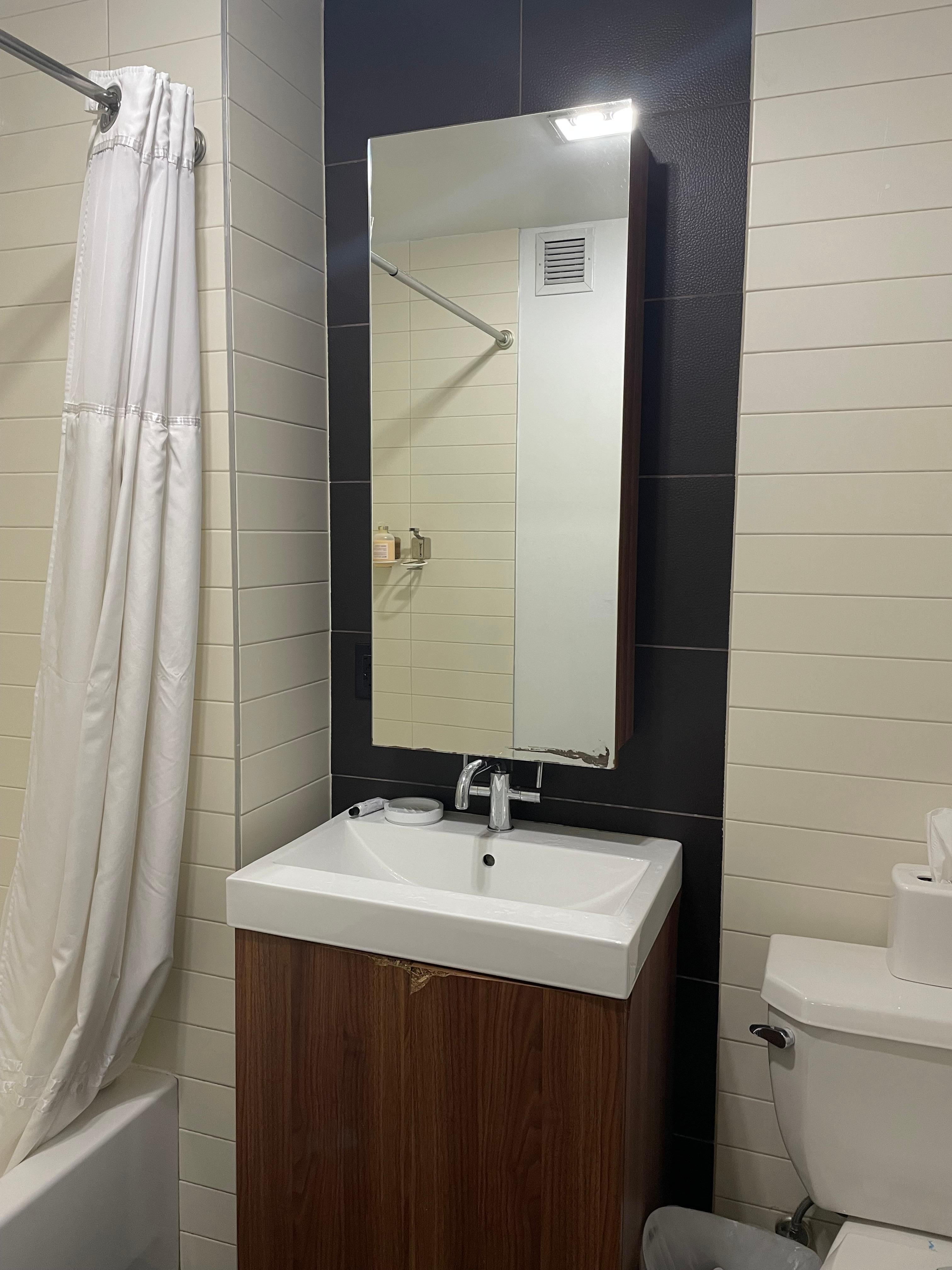 Damaged bathroom mirror door that wouldn’t shut and damaged cabinet.
