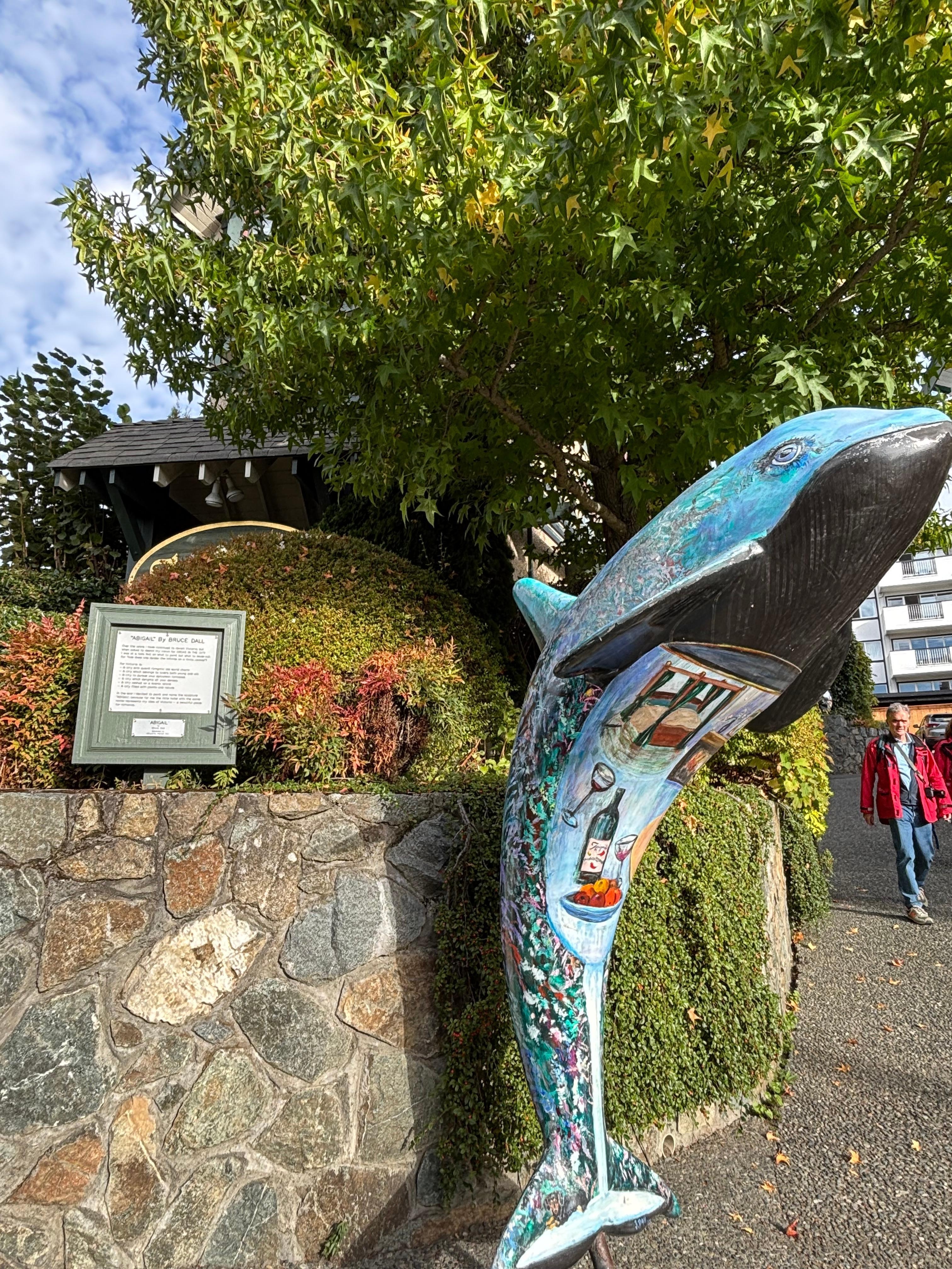 The unique sculpture at the entrance is surrounded by well kept shrubbery and blooming plants. 