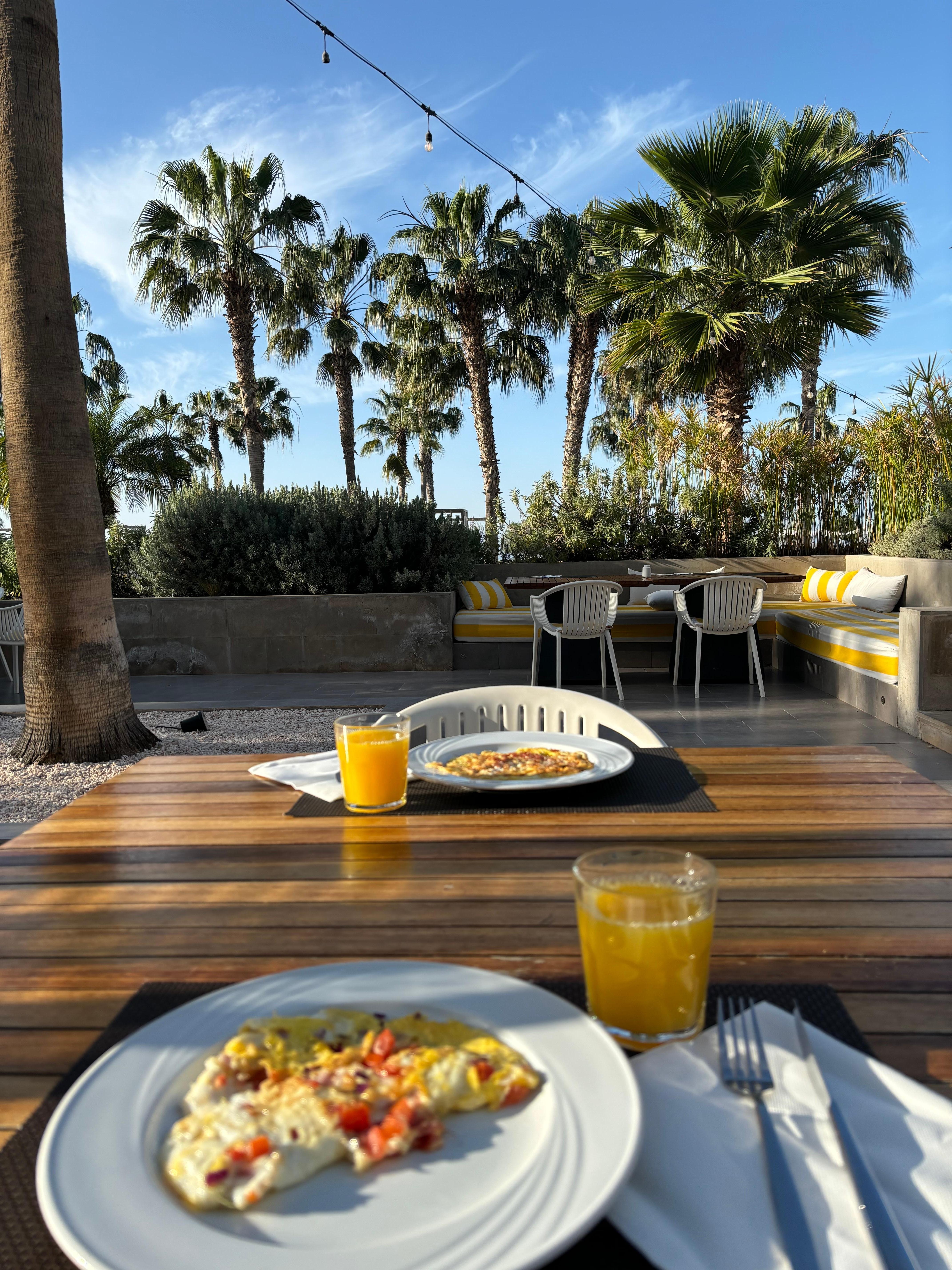 Dejlig morgenmad udenfor i solen, med nypresset appelsinjuice og frisk omelet