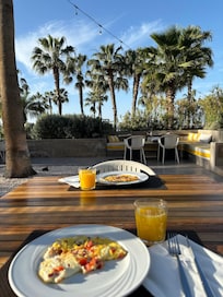 Dejlig morgenmad udenfor i solen, med nypresset appelsinjuice og frisk omelet