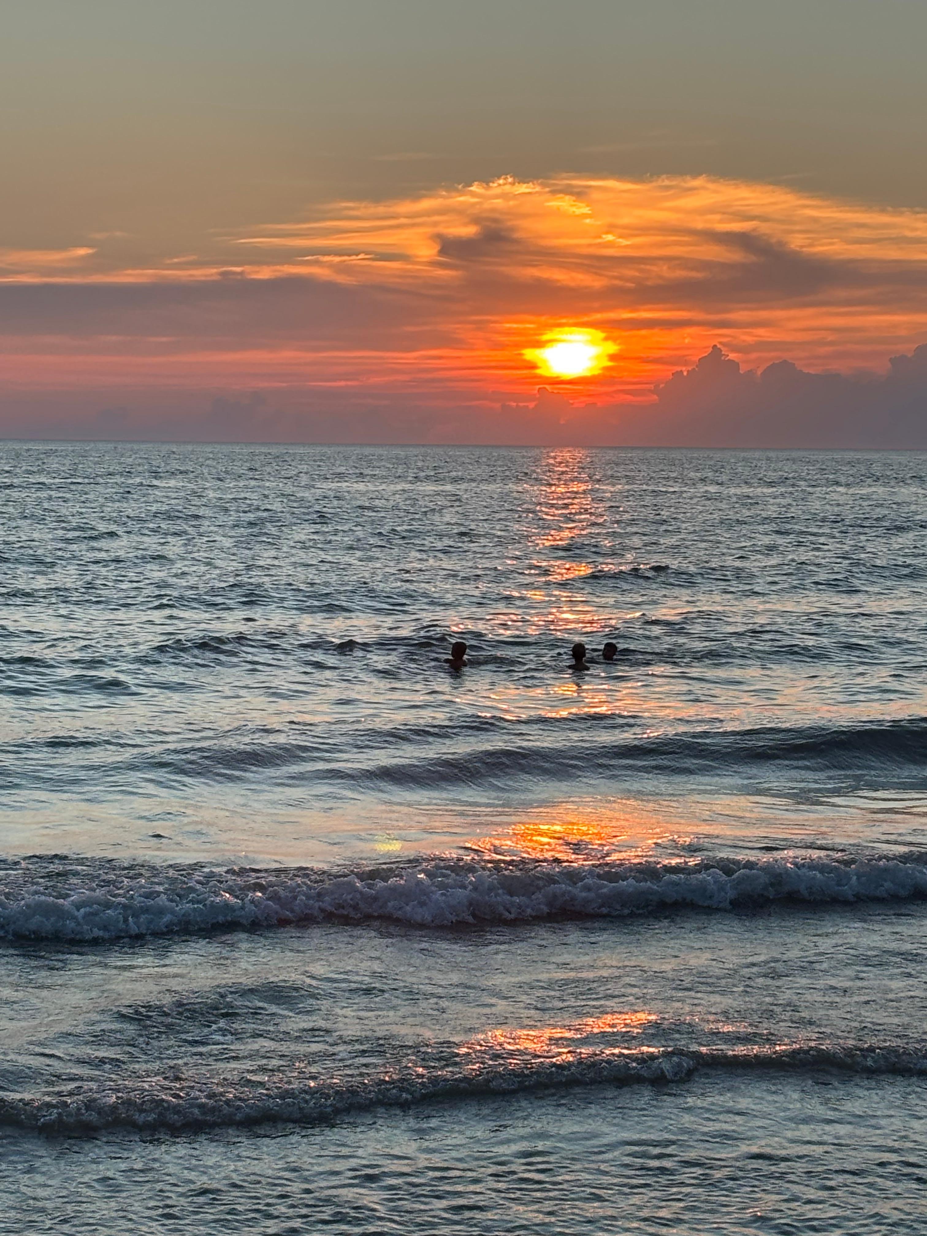 The kids watched the sun go down from the water.