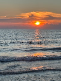The kids watched the sun go down from the water.