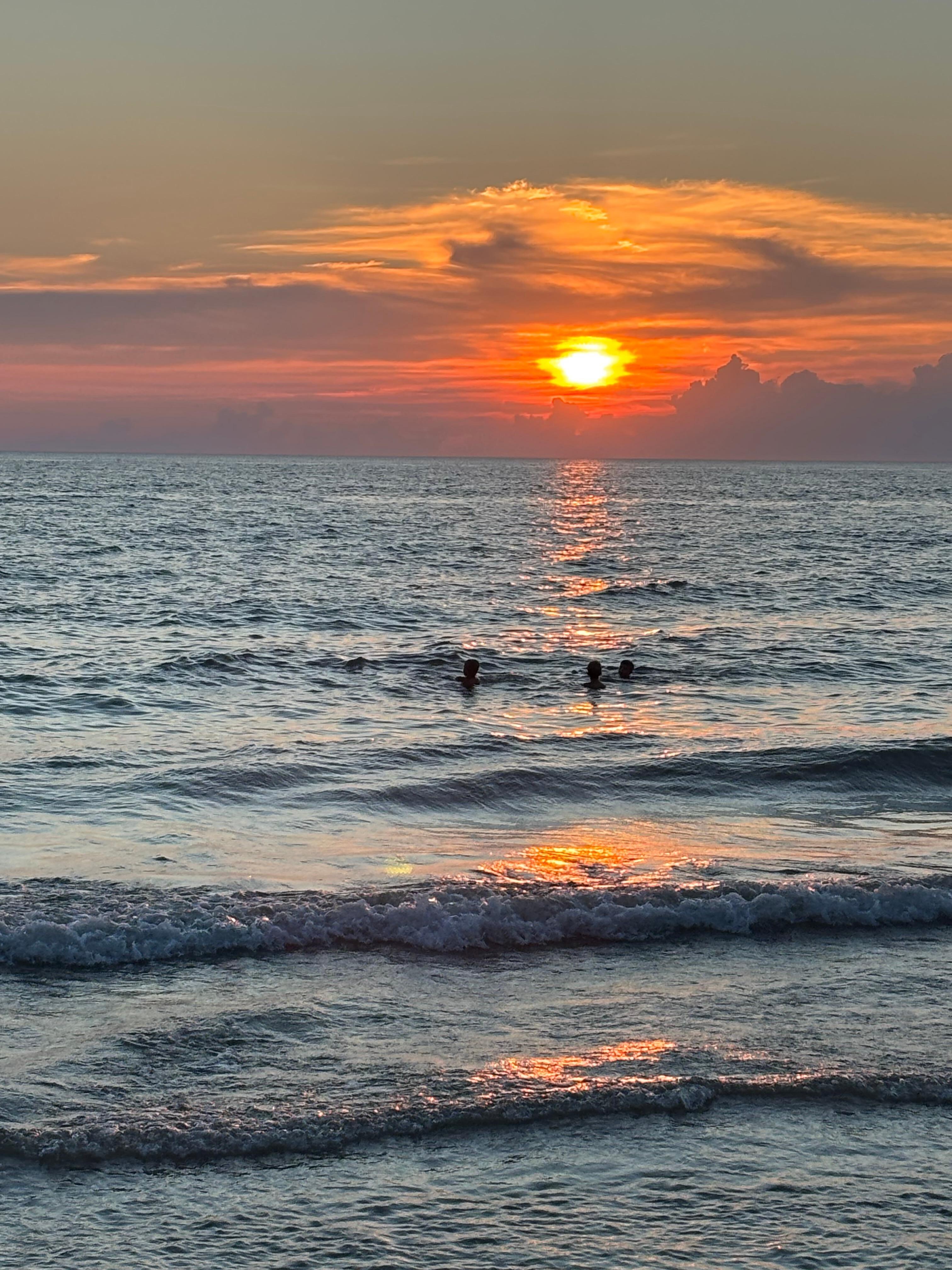 The kids watched the sun go down from the water.