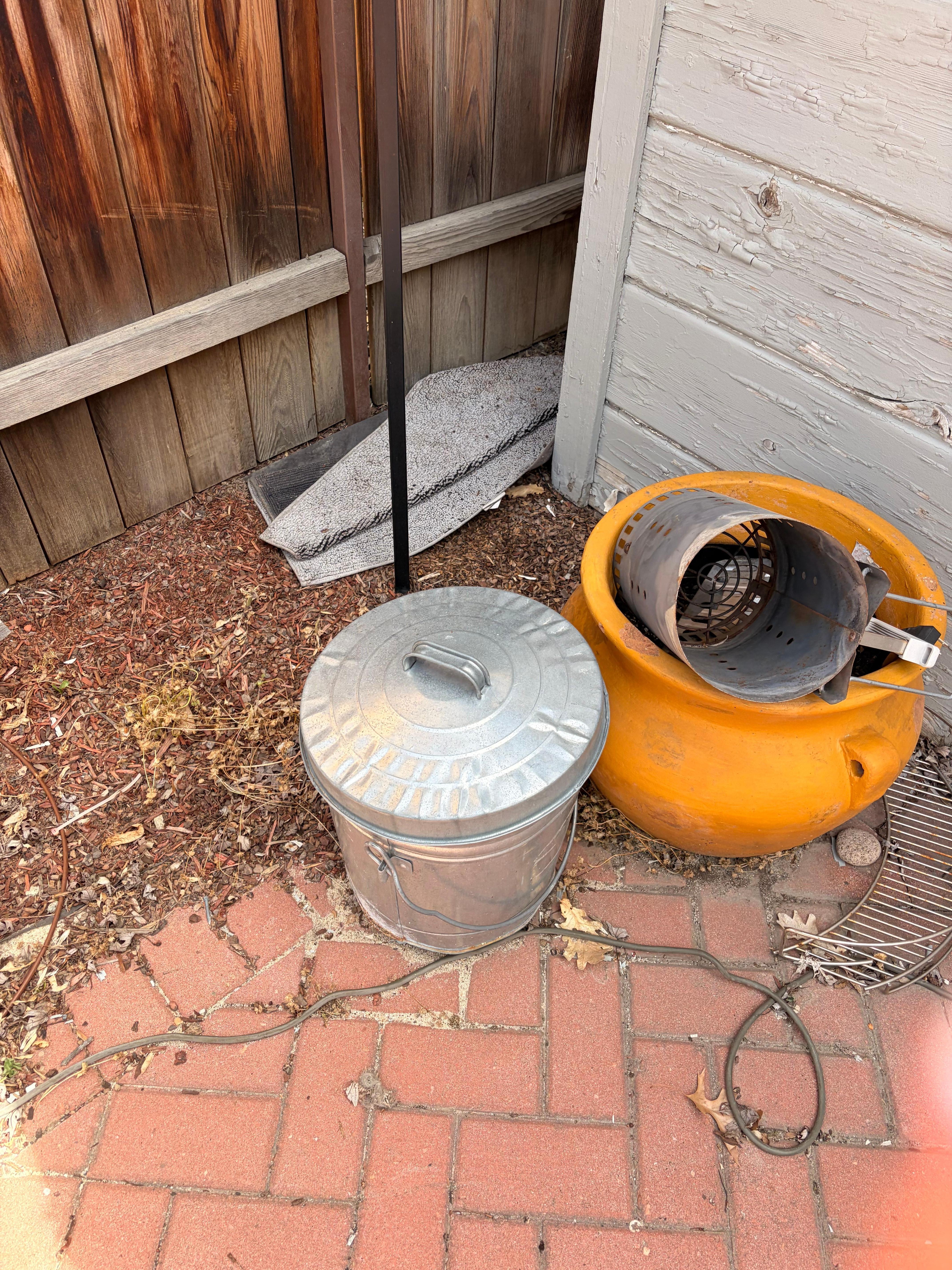 Patio area with water up rug left in the middle of it, which I threw off to the side and other random items laying around