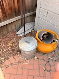 Patio area with water up rug left in the middle of it, which I threw off to the side and other random items laying around