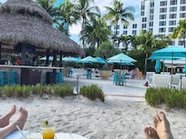 poolside bar with relaxing sandy lounger area
