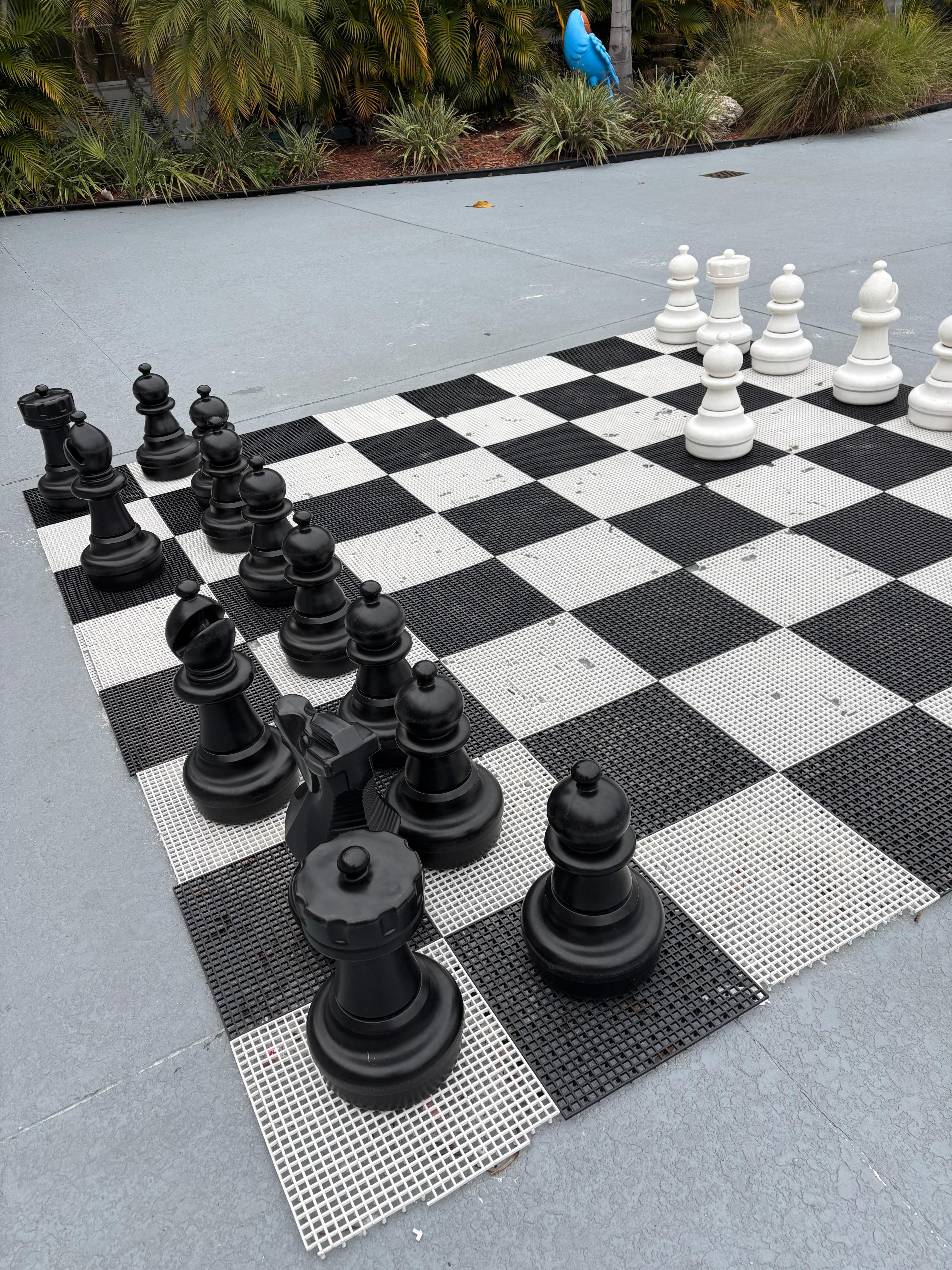 Website shows human size chess pieces. Chess pieces are broken and platform has multiple cracks