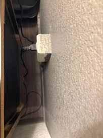 Dust next to the bed behind the night table.