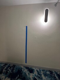 Tape holding peeling wallpaper in hallway