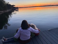 Grandma and kids watching a gorgeous lake sunset