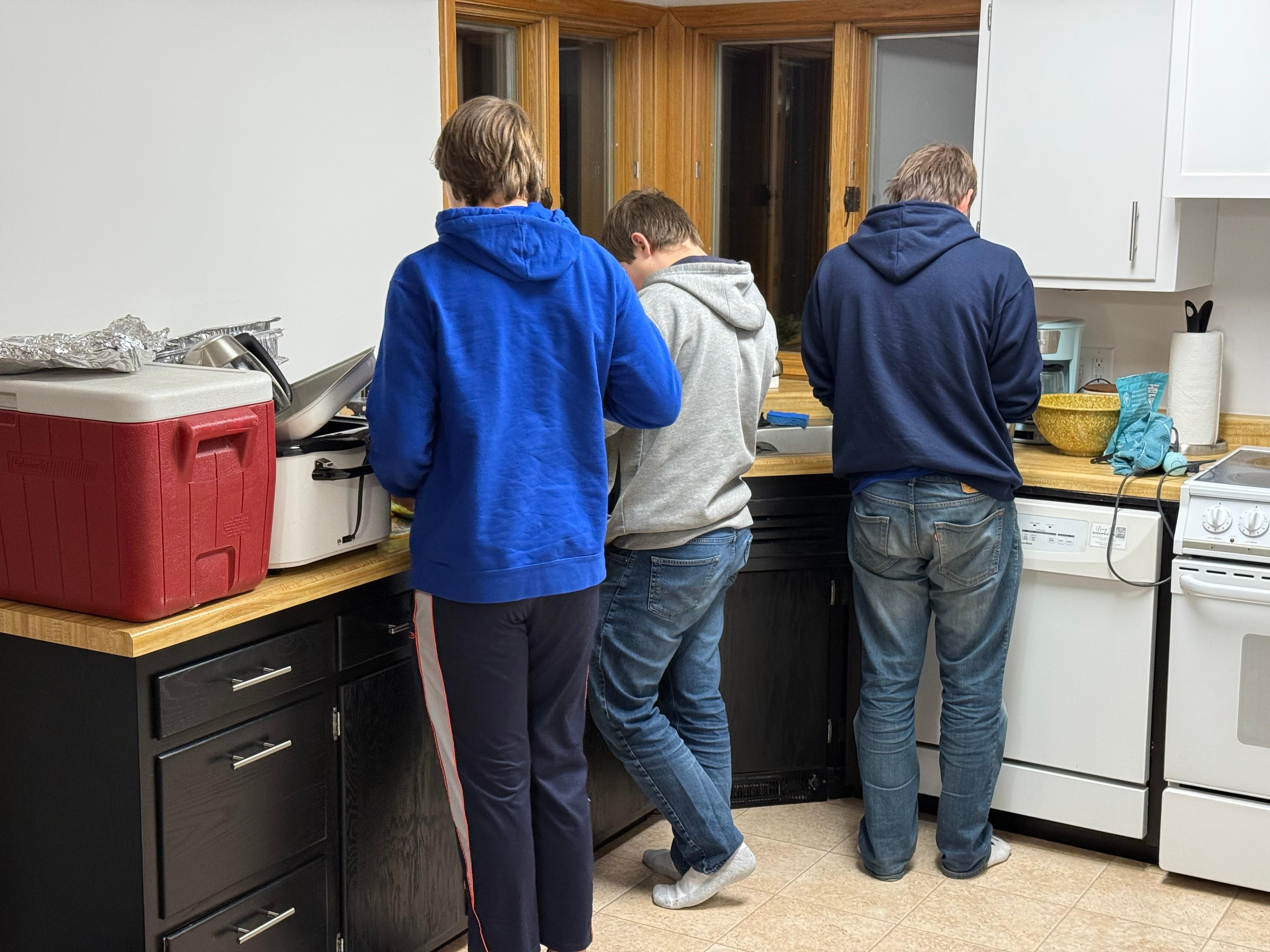 Three teen boys making a French silk pie for Thanksgiving. The kitchen is nice and spacious. 