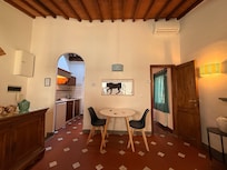 cute living space with a nice little kitchen, a few seating options, and windows on two sides of the apartment