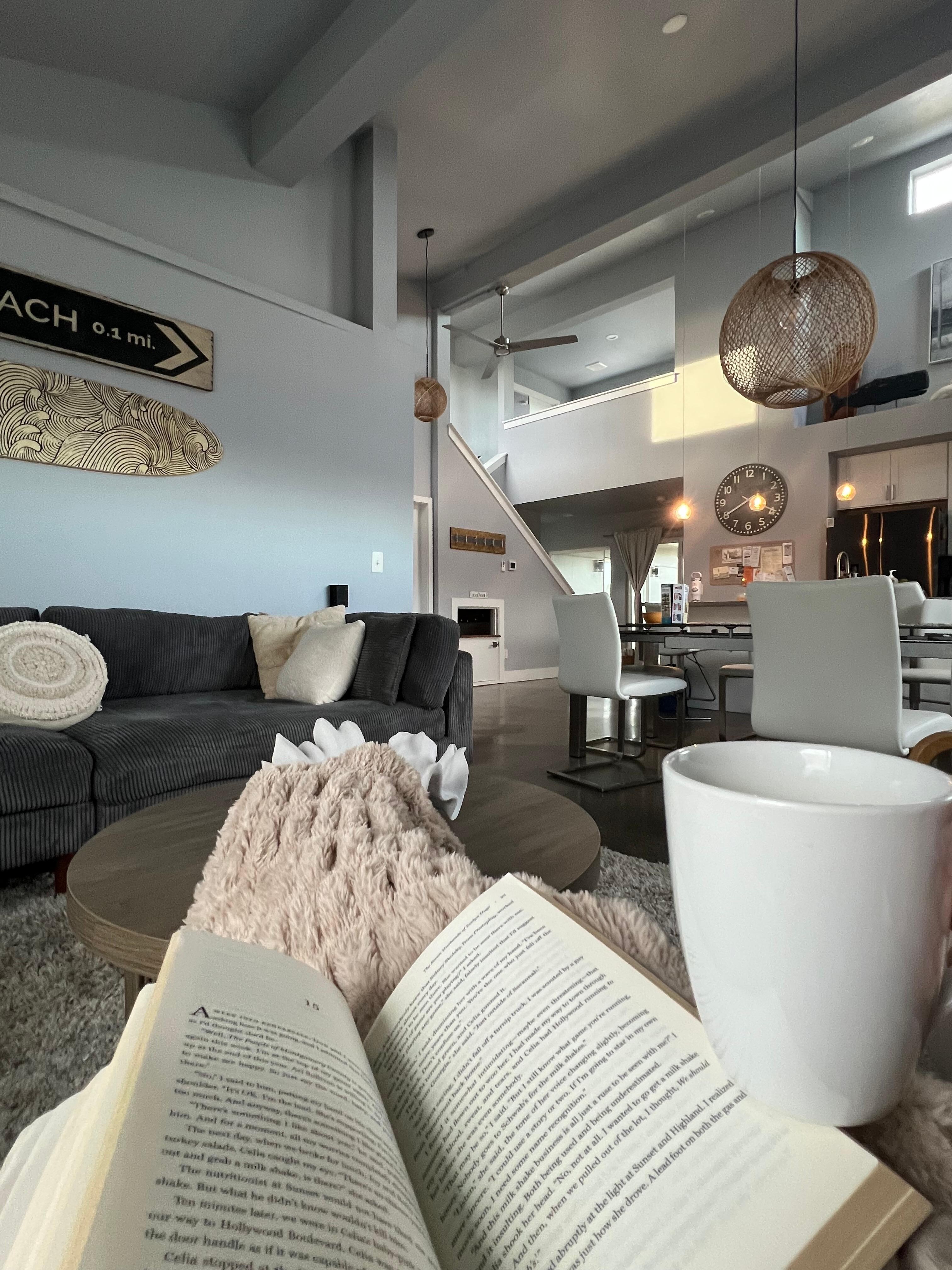 Coffee and a book next to the fireplace. 