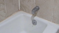 Bathtub stains with orange mold.