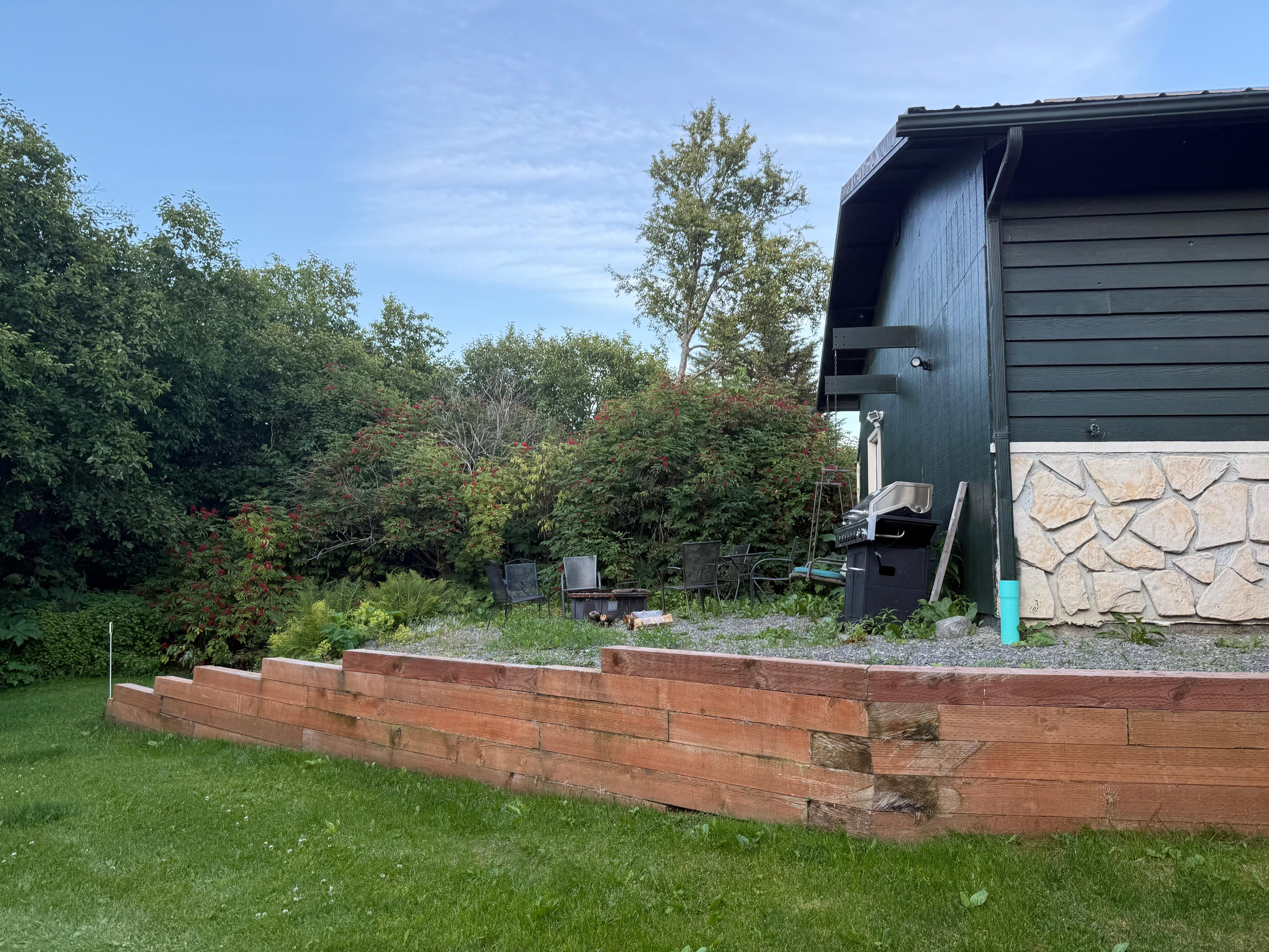 Raised area contains a fire pit and sitting area