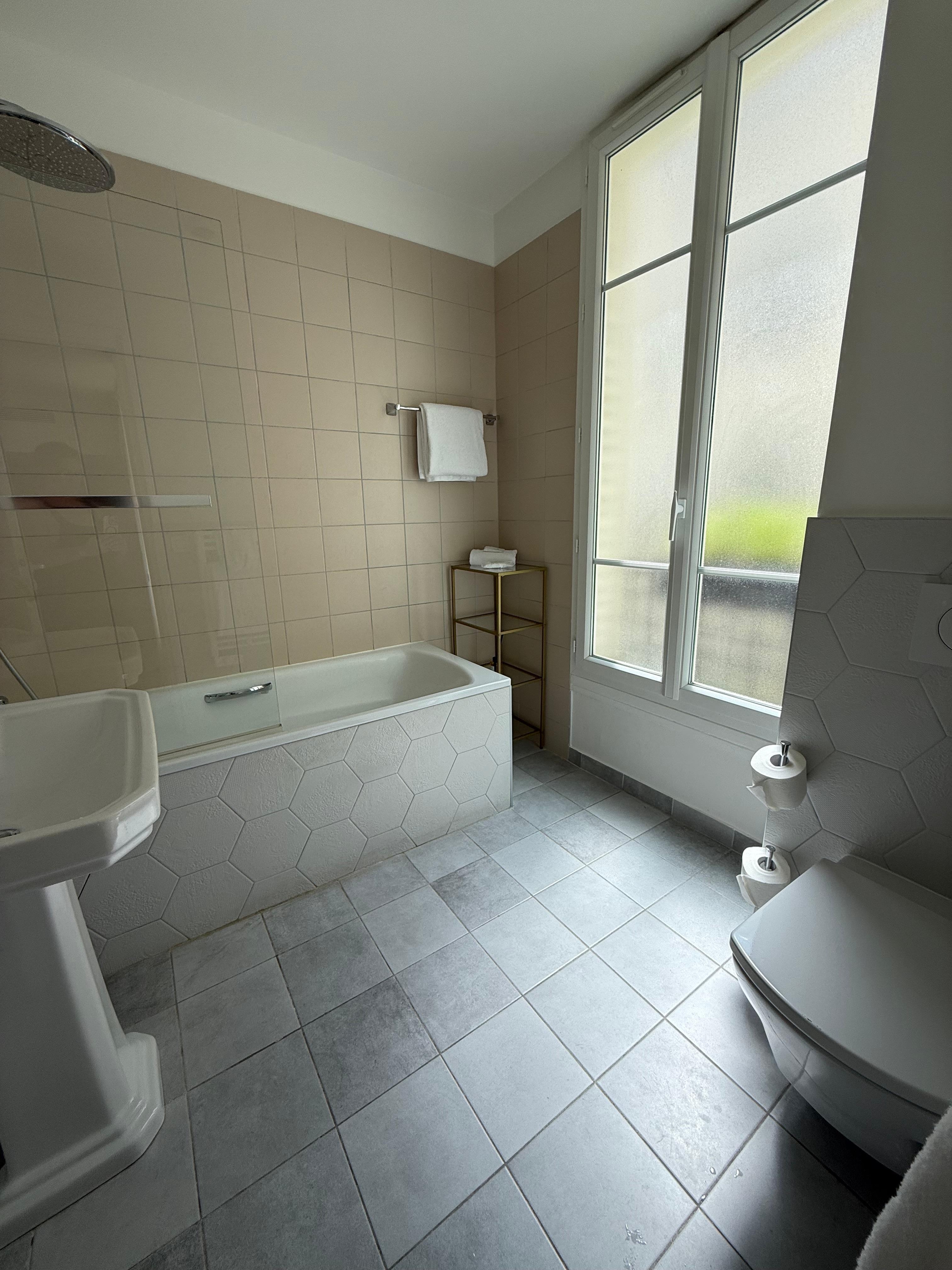 Big bathtub with handheld shower option and rain shower combo.