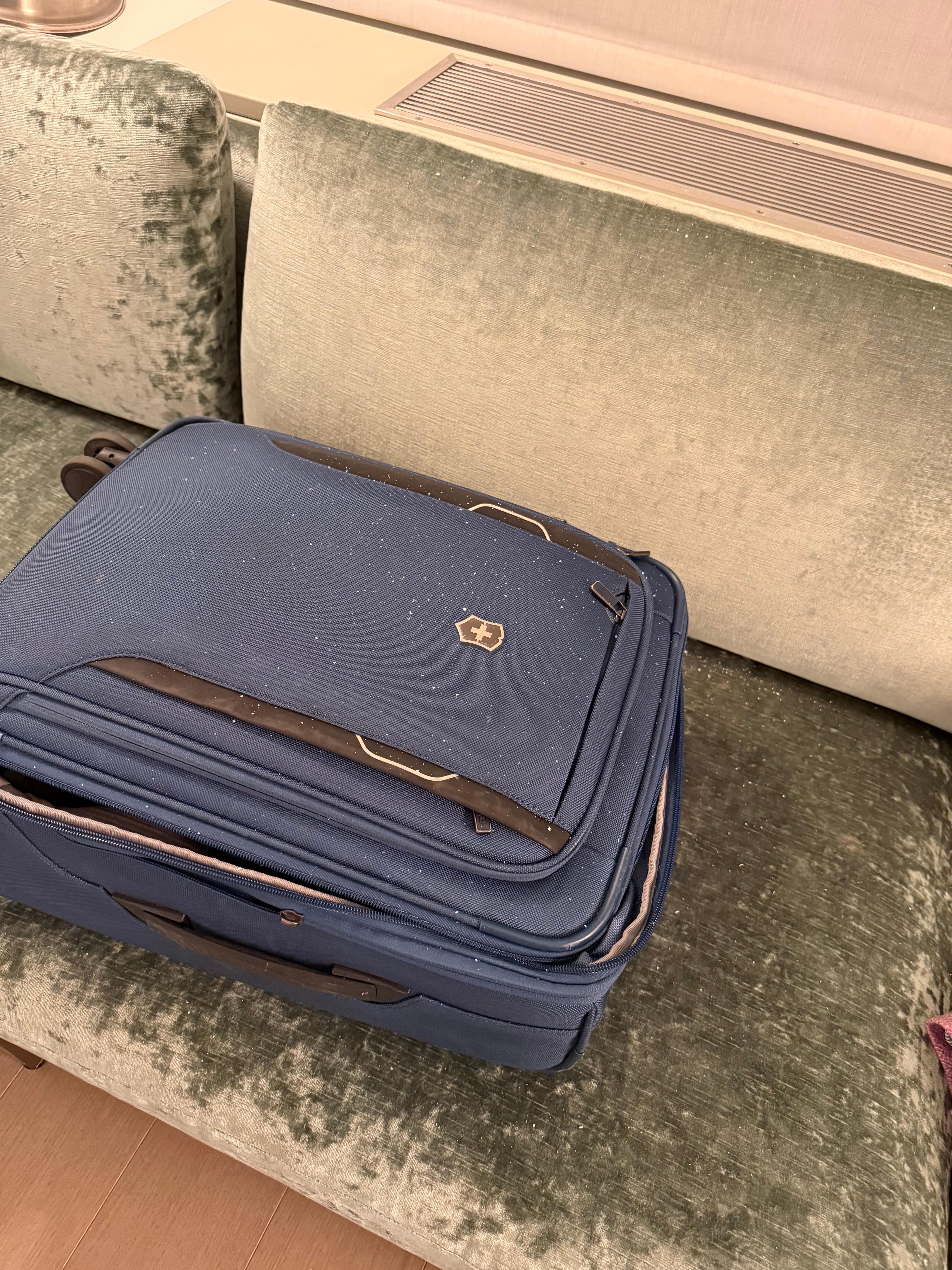 White flecks from hvac vent-  I had left my suitcase open and had to shake out all my clothes.  It looks like white cigarette ash 