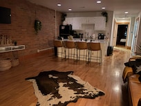 Standing against the jungle plants and the street-side windows, looking into the kitchen.