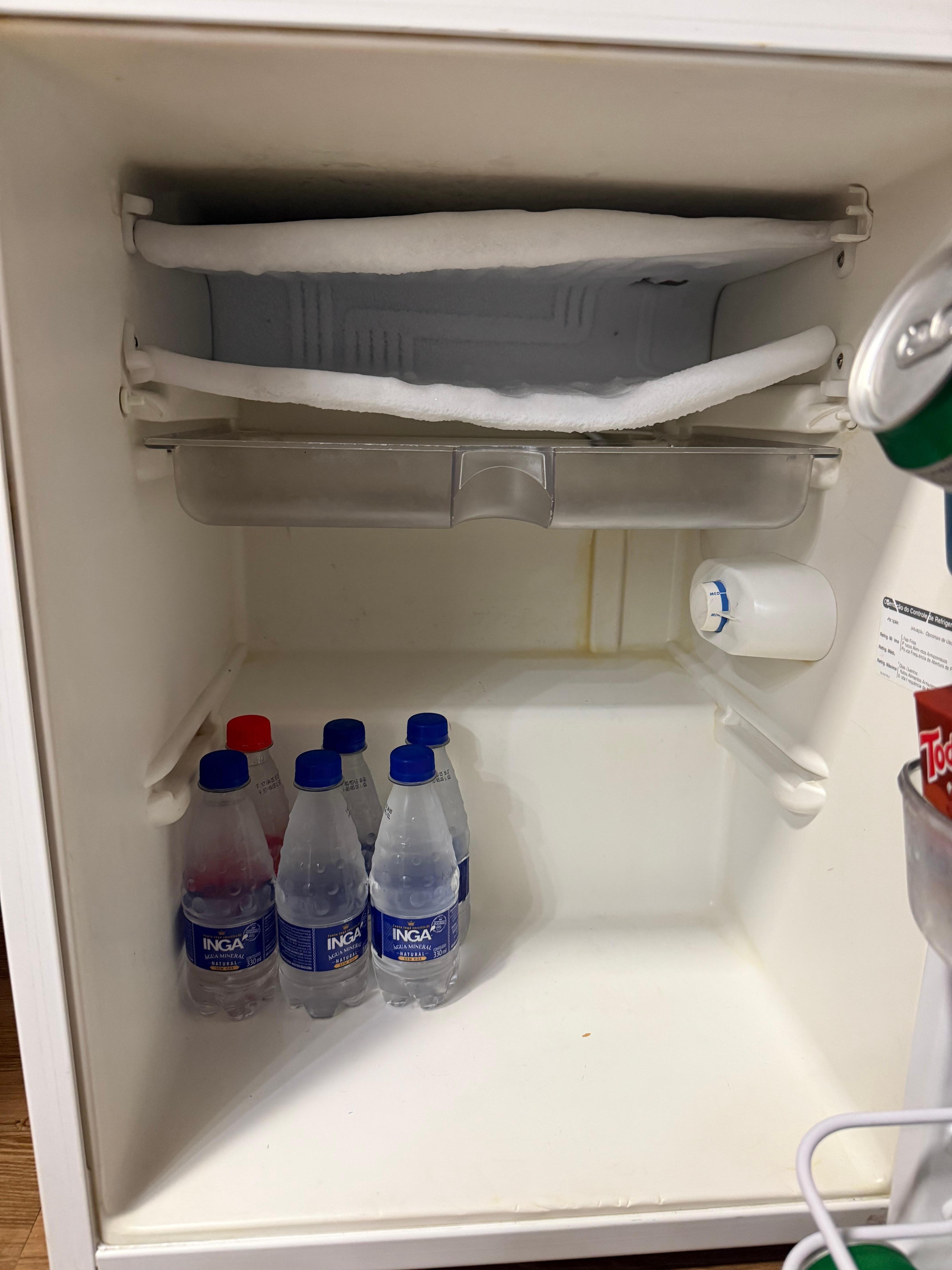 dirty and broken fridge, yellow liquid dripping from the back
