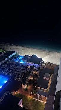 Pool and outdoor bar view from room at night.