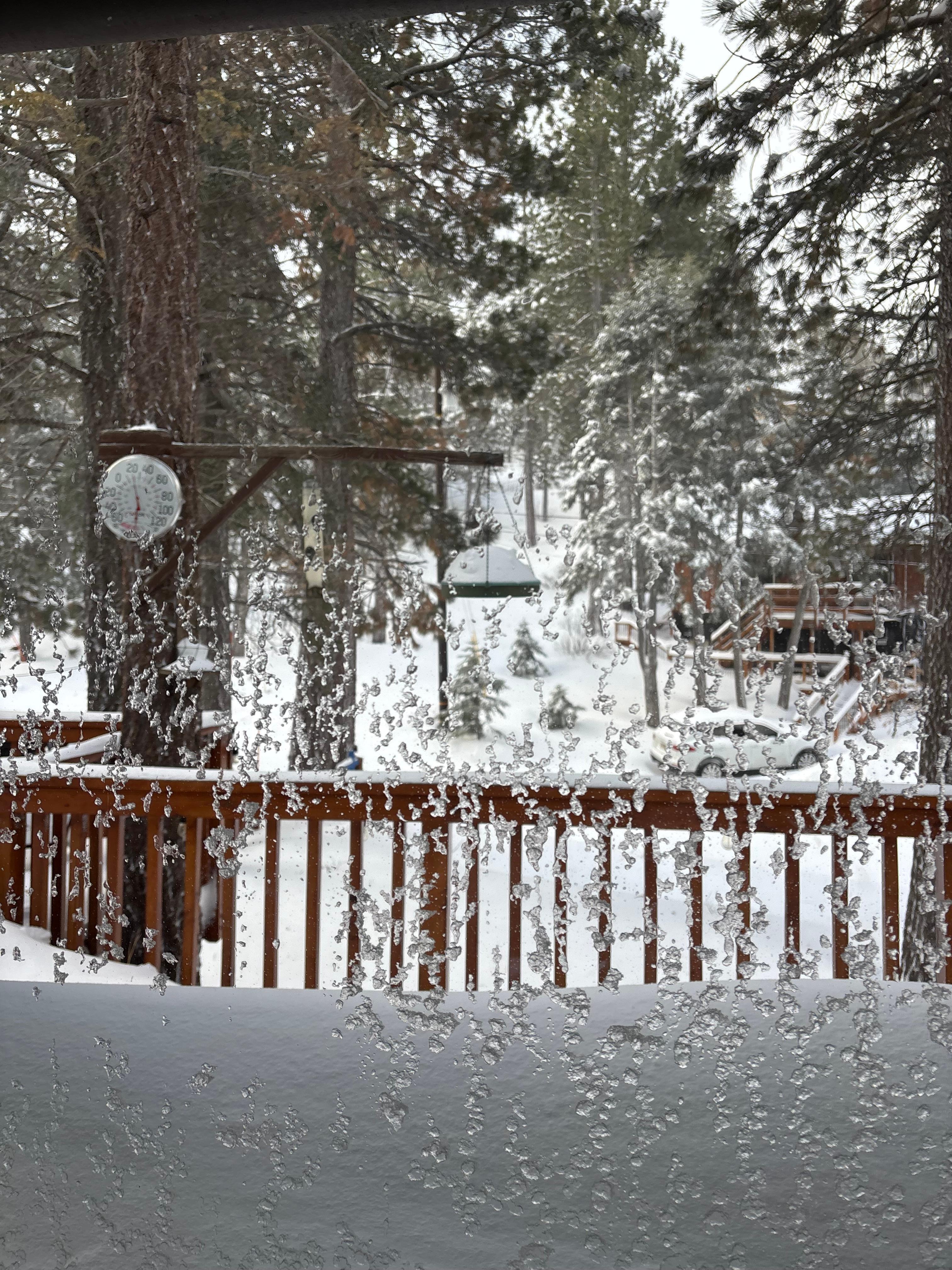 Large front window of cabin. Snowfall after overnight blizzard 