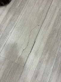 this isn't just a crack, its a full board that sinks and is right in the middle of the room.