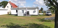 Die Rückseite vom Bungalow mit kleiner Sonnenterrasse. Die Vorderseite ist komplett überdacht.