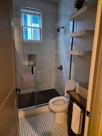 No window treatment in bathroom with neighboring window right there