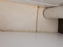 Hair and dirt on floor by rubber bathtub mat