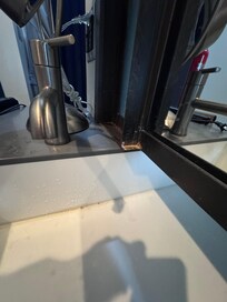 The sink and the wall with the opening from the room to the bathroom