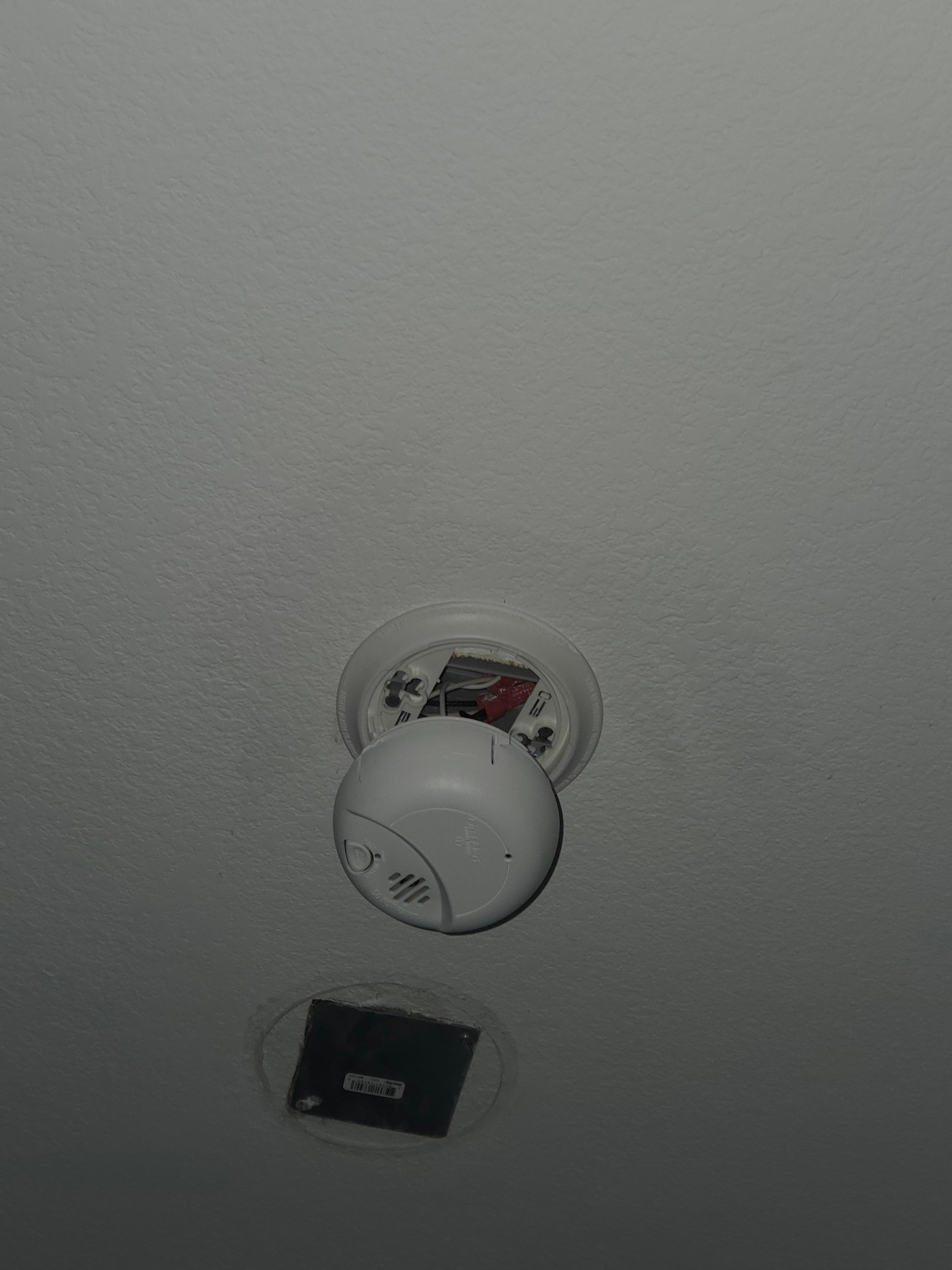 Smoke detector hanging down off of ceiling