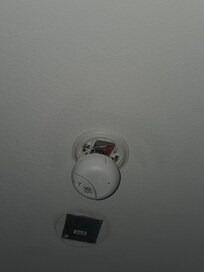 Smoke detector hanging down off of ceiling