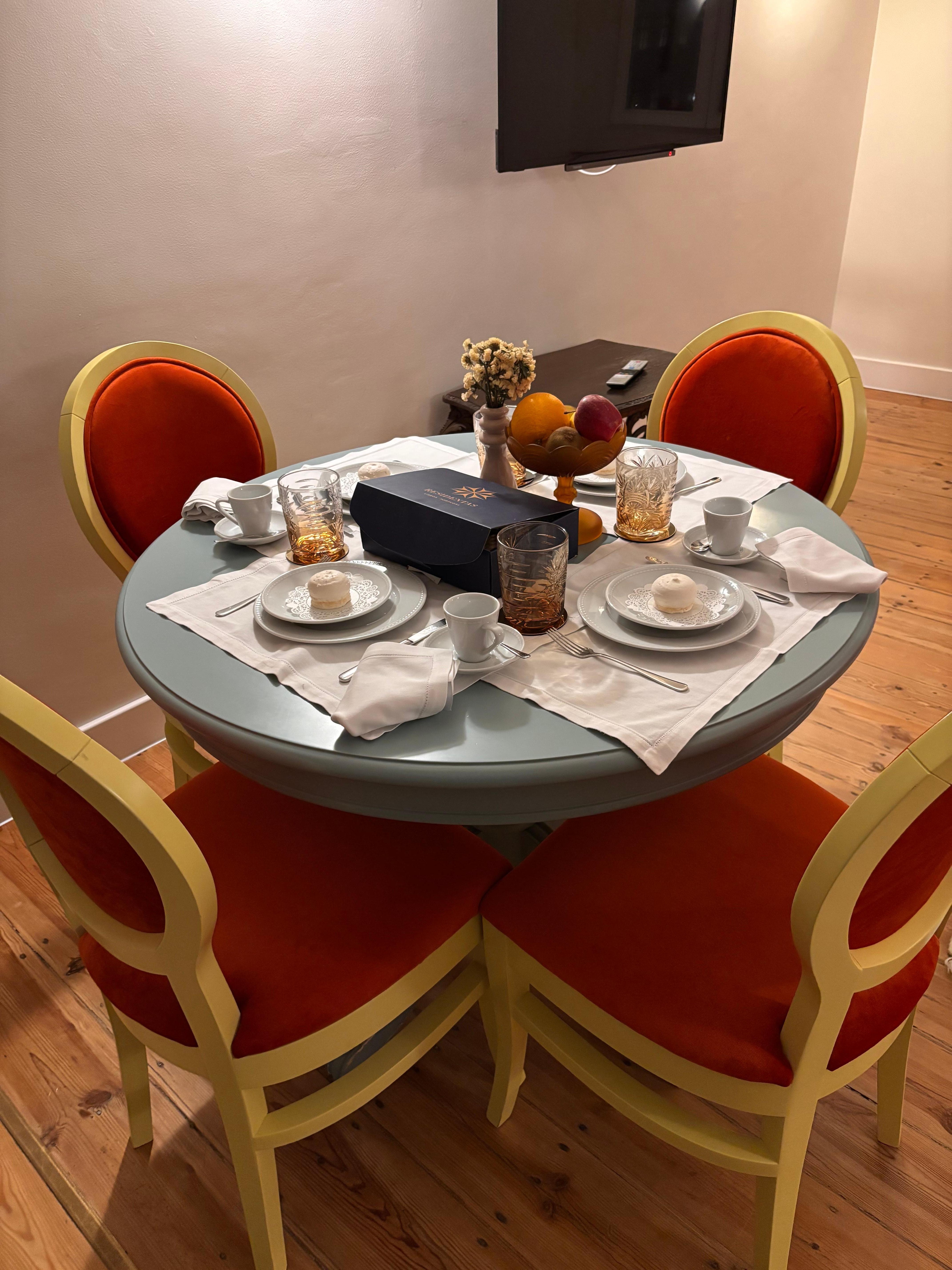 Table set with coffee supplies, macaroon, and linens. 