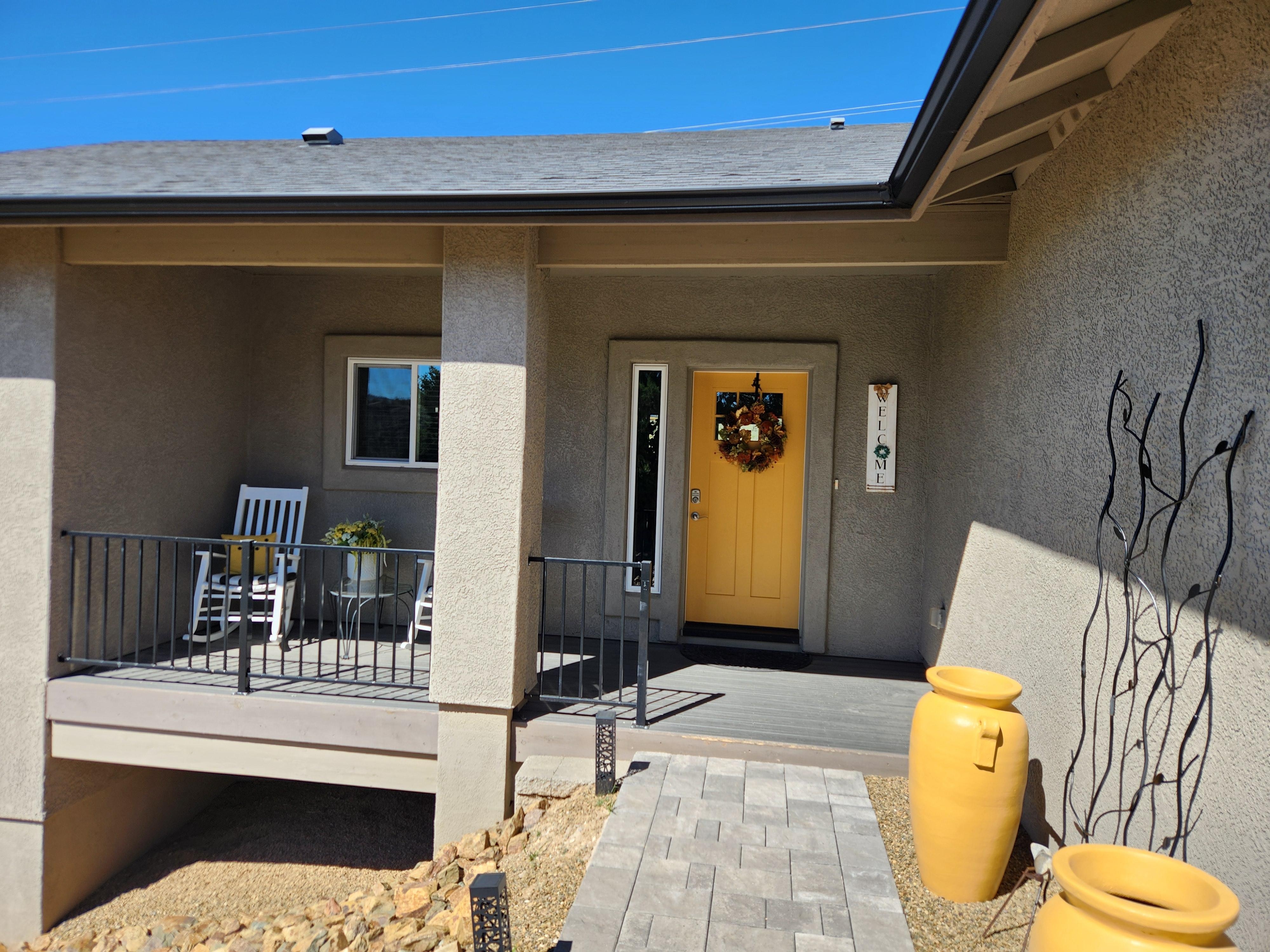 Front entrance and patio with two rocking chairs.