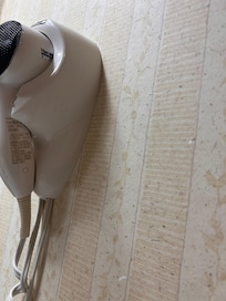 Orange drip marks on hair dryer and toothpaste splatter on wall