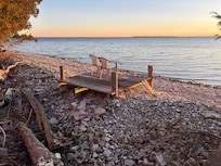 Seating lakeside at the bottom of the stairs below the house
