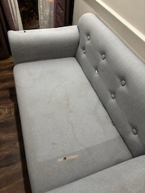 Replacement room given with dirty and torn sofa