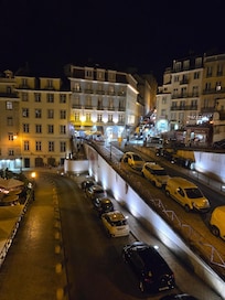View of hotel from the 3rd floor entrance of the Rossio train station. Hotel is in center of frame and the first floor is lit by bluish lights.