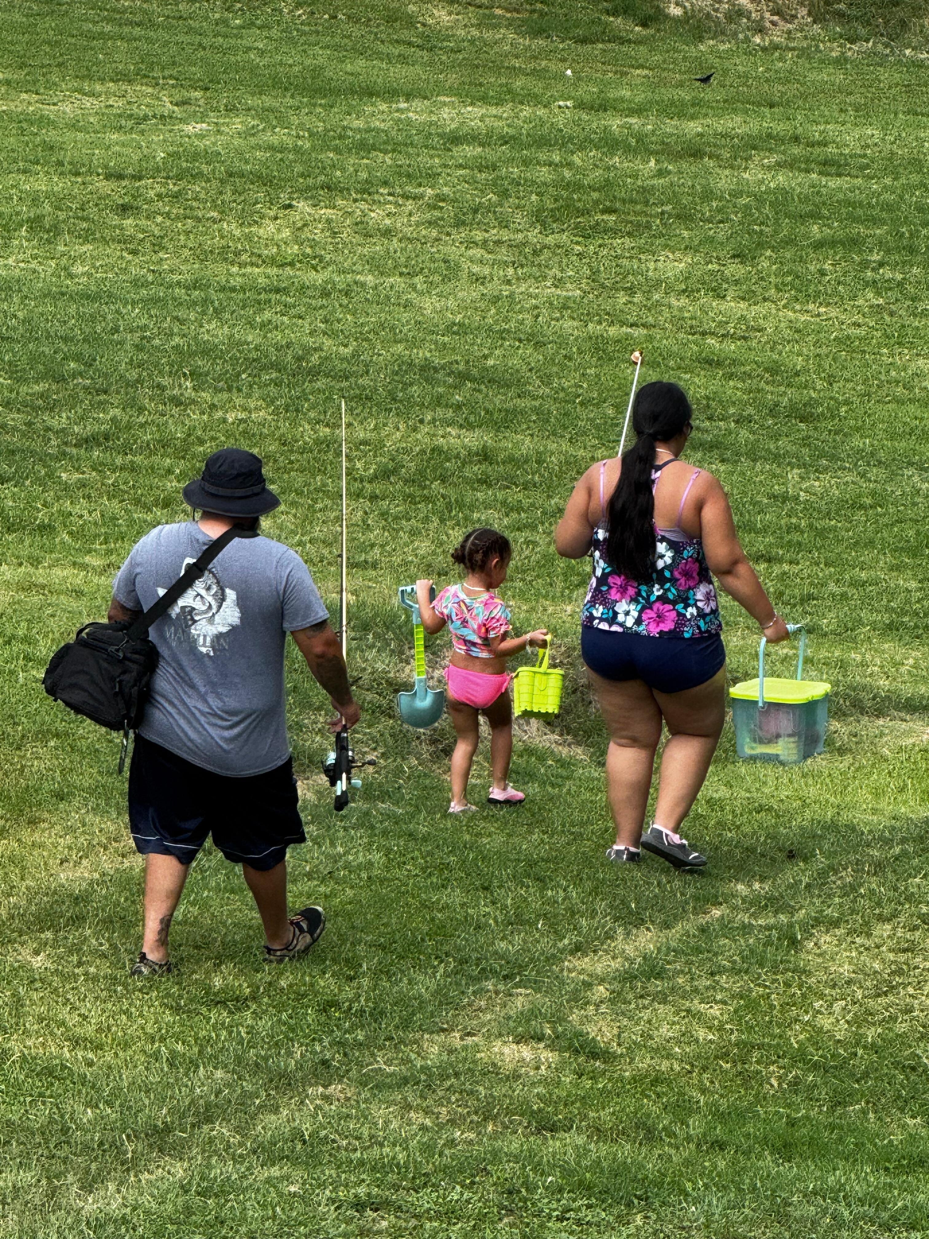 Picture taken from balcony, family on their way to fish. 