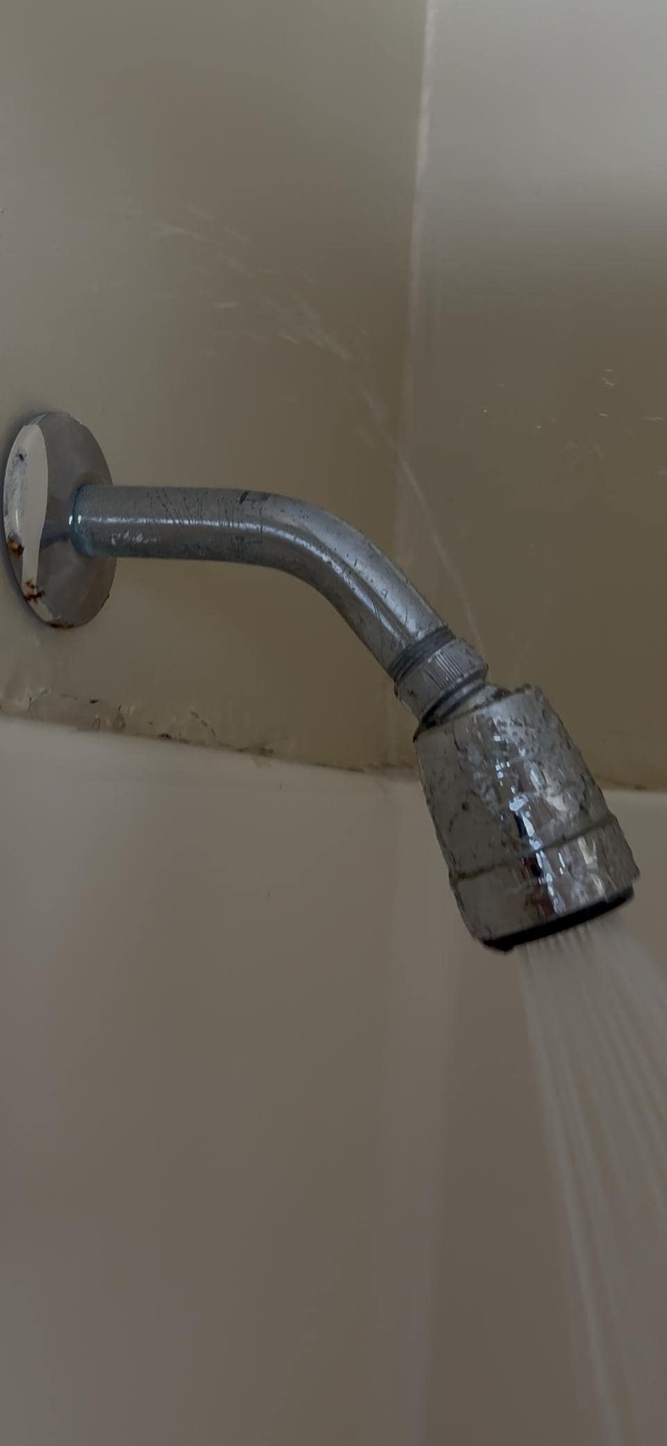 Leaking shower head spraying water out of shower. 